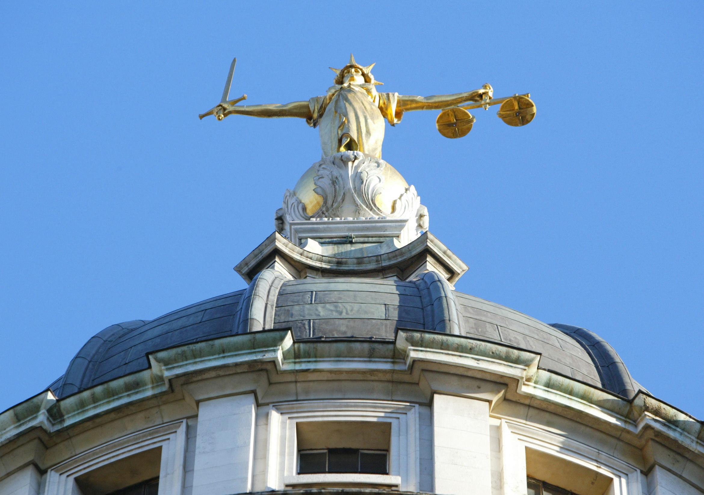 The statue of justice stands on the cupola of the Old Bailey courthouse photographed after Ian Huntley was sentenced to two life terms in prison for murdering 10-year-old schoolgirls Holly Wells and Jessica Chapman and his girlfriend, Maxine Carr, was convicted of preventing the course of justice on December 17, 2003, in London, England. | Source: Getty Images