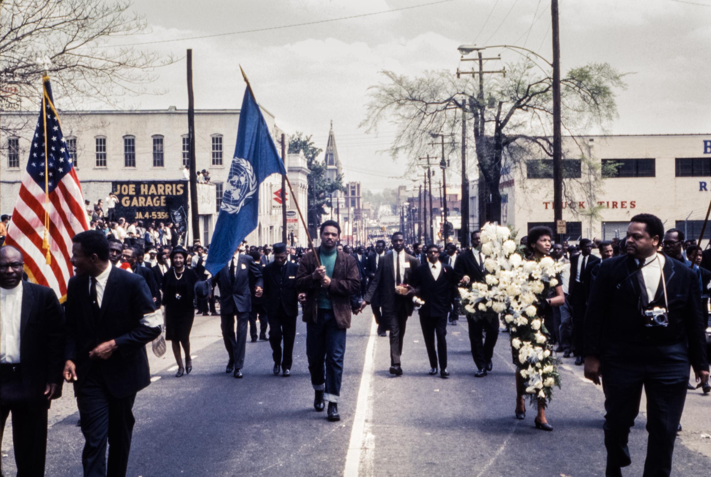 Jesse Jackson carries the United Nations flag in the funeral procession of Rev. Martin Luther King, Jr. on April 9, 1968. | Source: Getty Images