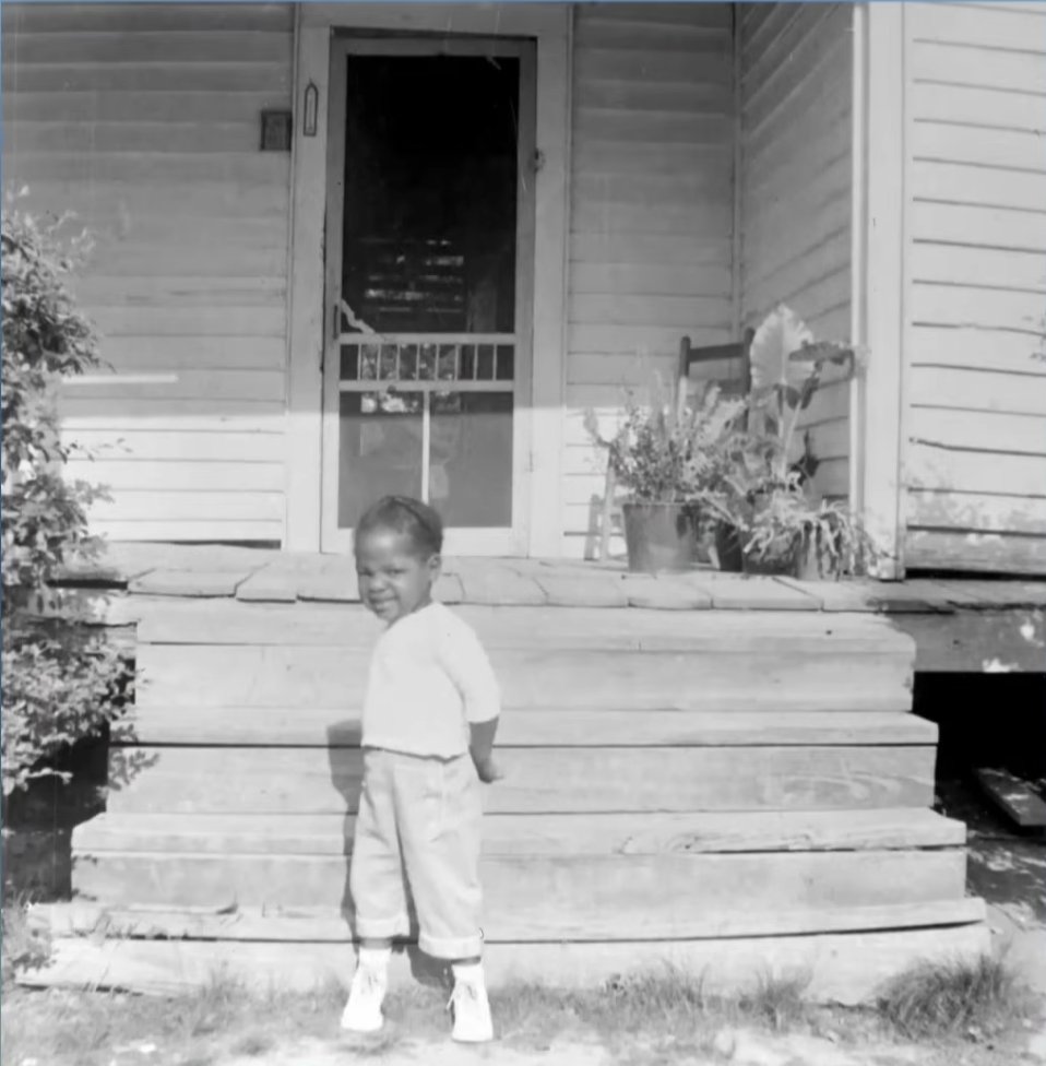 The legendary TV host as a young girl in front of her childhood home, from a video dated April 30, 2021 | Source: YouTube/DoctorOz
