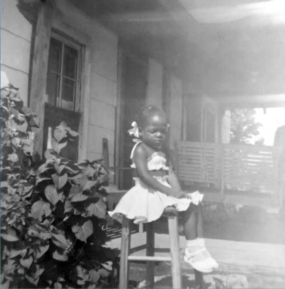 The legendary TV host as a young girl in front of her childhood home, from a video dated April 30, 2021 | Source: YouTube/DoctorOz