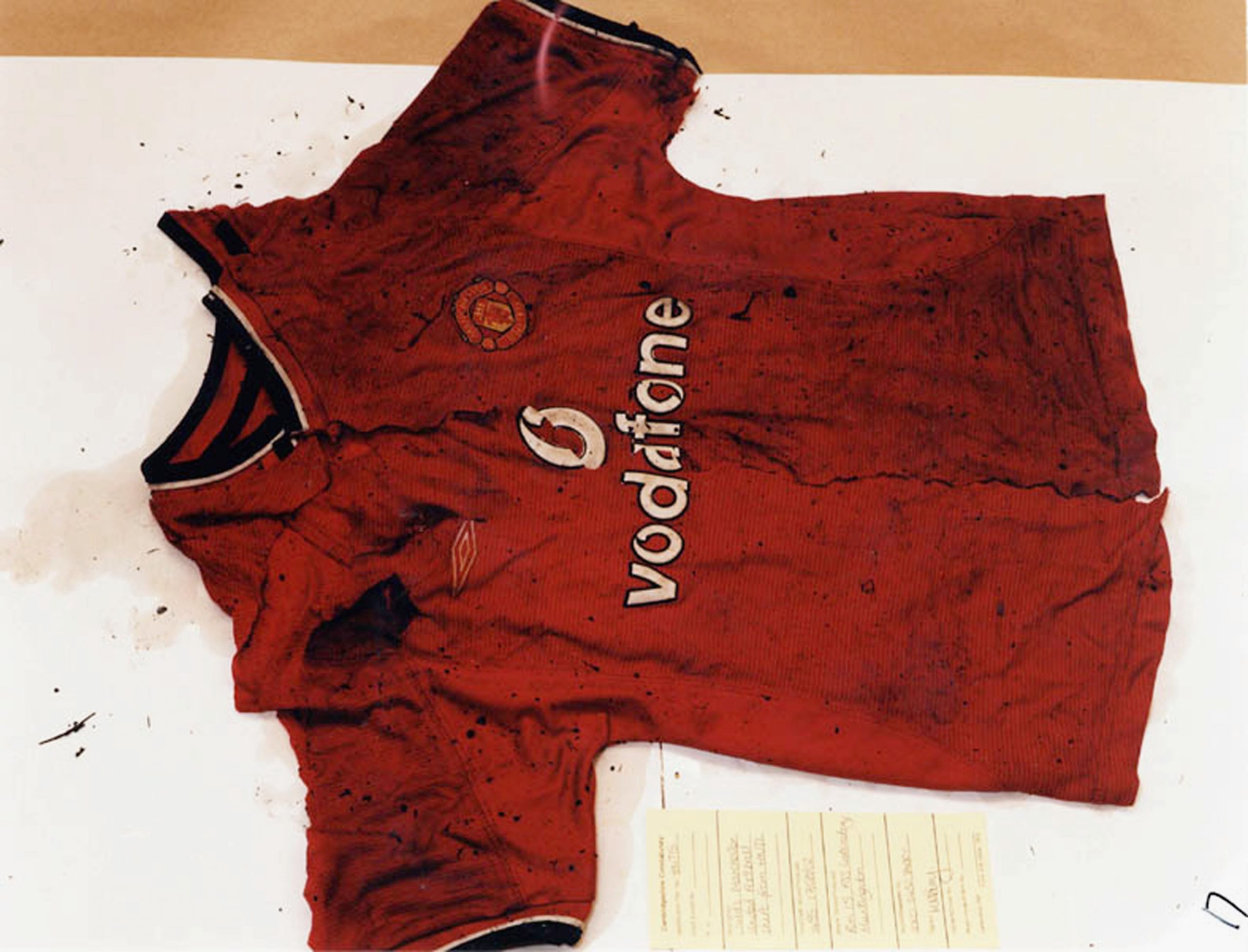 An undated handout photo showing the burnt remains of a red Manchester United shirt belonging to one of the two murdered 10-year-old girls, which was found along with traces of Ian Huntley's hair in the school grounds where he worked in Soham, England. | Source: Getty Images