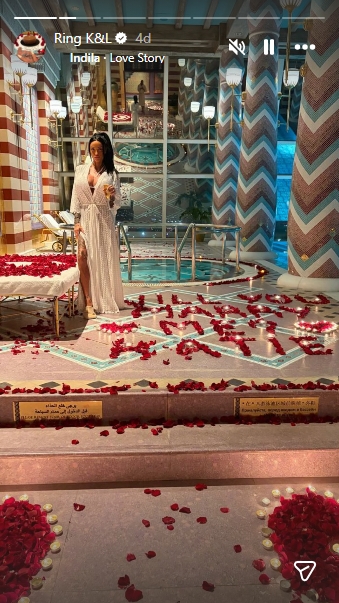 Katie Price poses in a rose-petal-filled setting where the words 