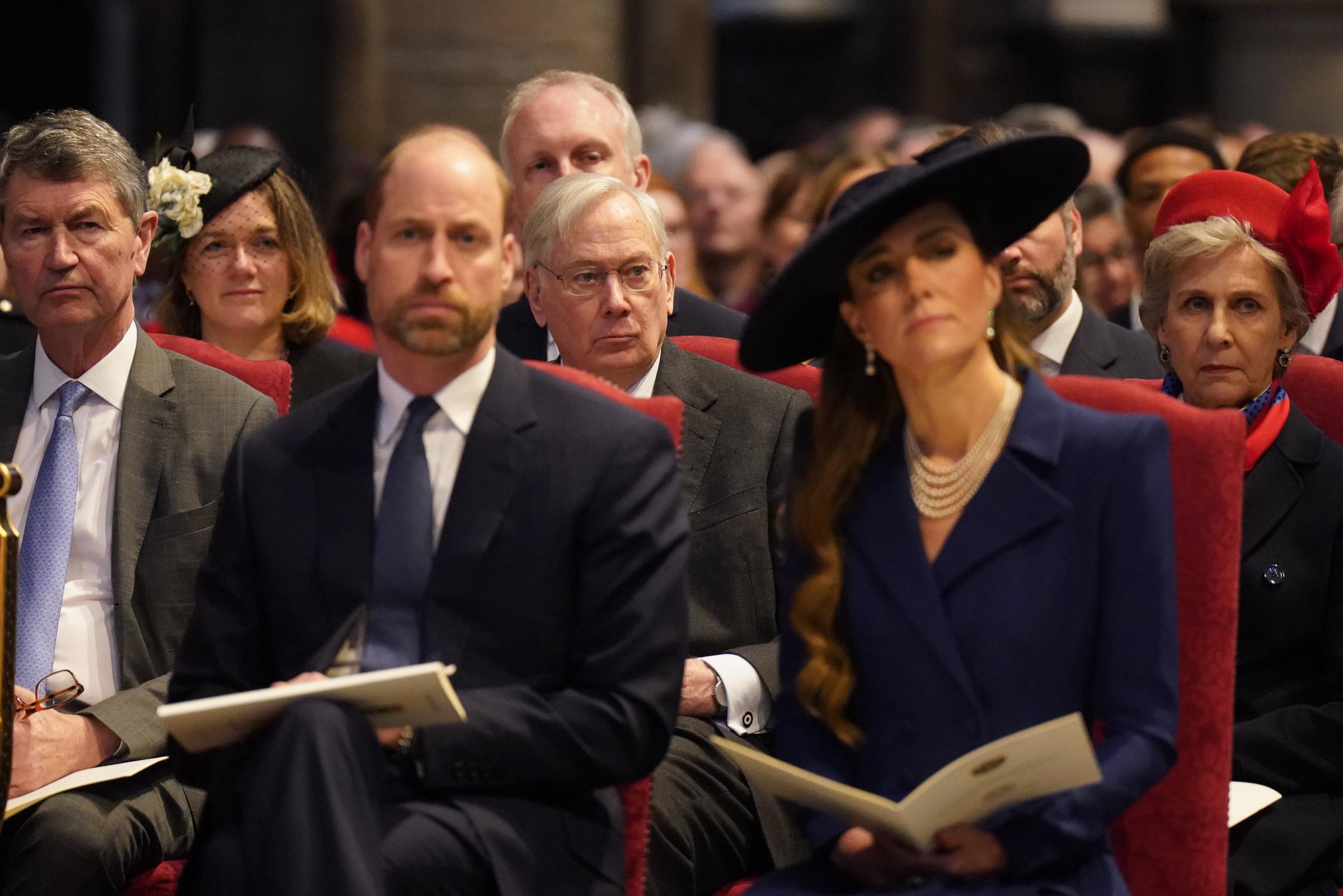 The Prince of Wales and the Princess of Wales sat side by side in the red-cushioned pews of Westminster Abbey on 9 March 2026, each holding their order of service booklet, the Princess's layered pearl necklace and wide-brimmed navy hat catching the eye as the Duke of Gloucester sat attentively in the row directly behind them.