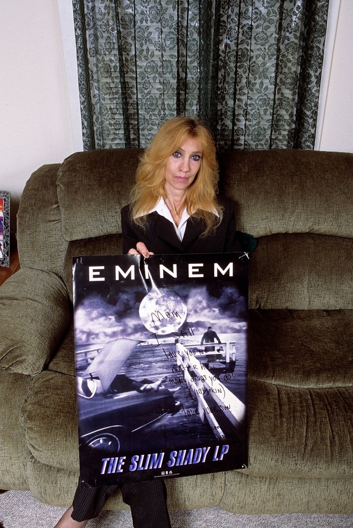 Eminem's mother, Debbie Nelson, holds a poster with a handwritten message during a portrait session at her home in September 2005 in Detroit, Michigan. | Source: Getty Images