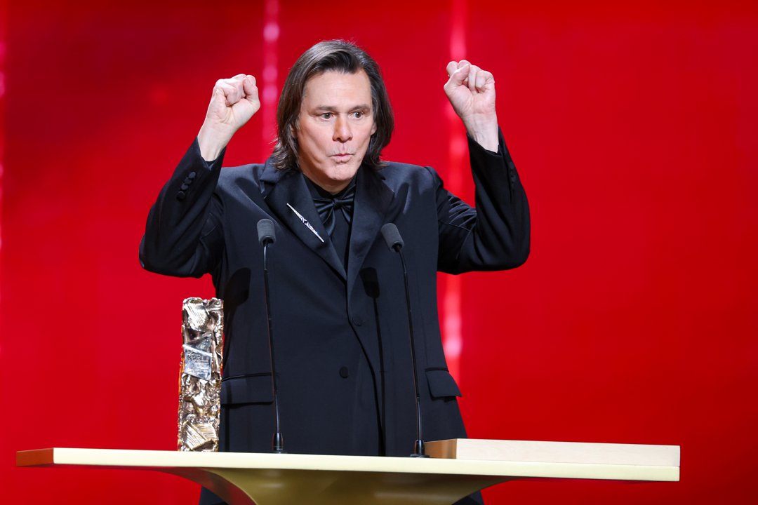 With both fists raised mid-gesture, Jim Carrey delivers an animated moment onstage. Dressed in a sharp black tuxedo, he stands behind the podium beside his Honorary C&eacute;sar Award. The lively expression plays out during the 51st C&eacute;sar Film Awards at L'Olympia in Paris, France.