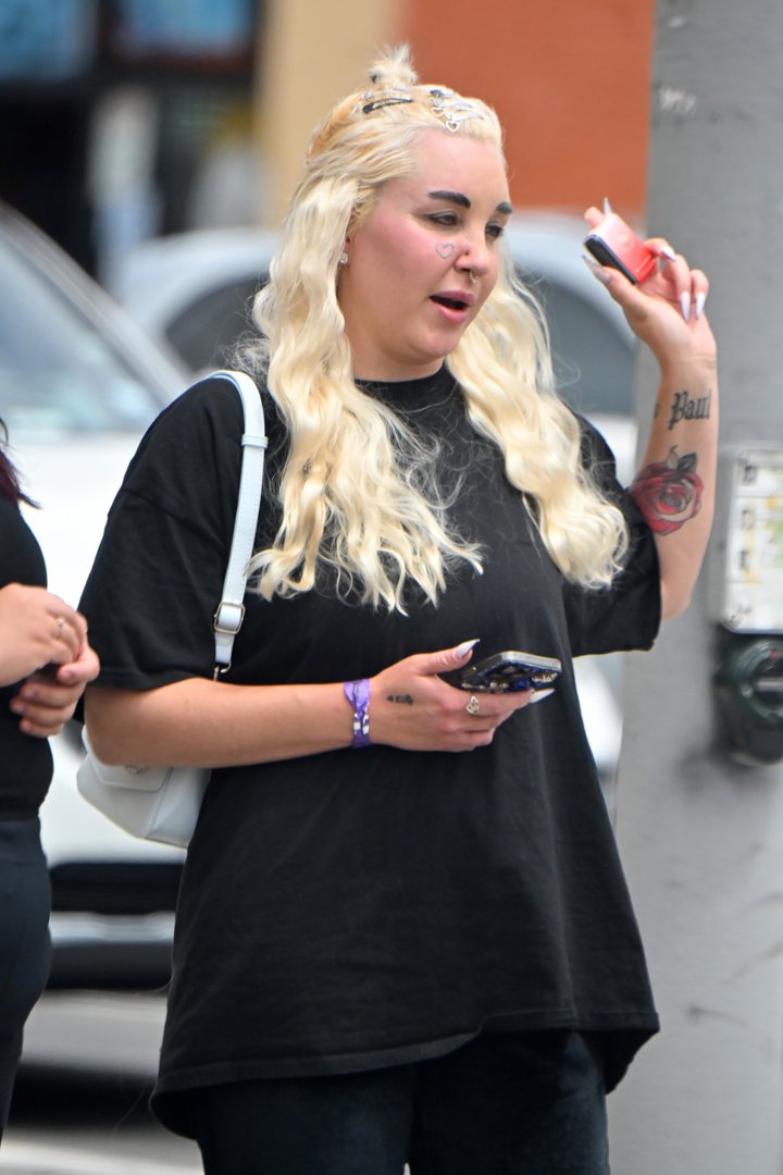 Amanda Bynes holding a small object while speaking to someone during an outing in Los Angeles, California on April 25, 2024. | Source: Getty Images