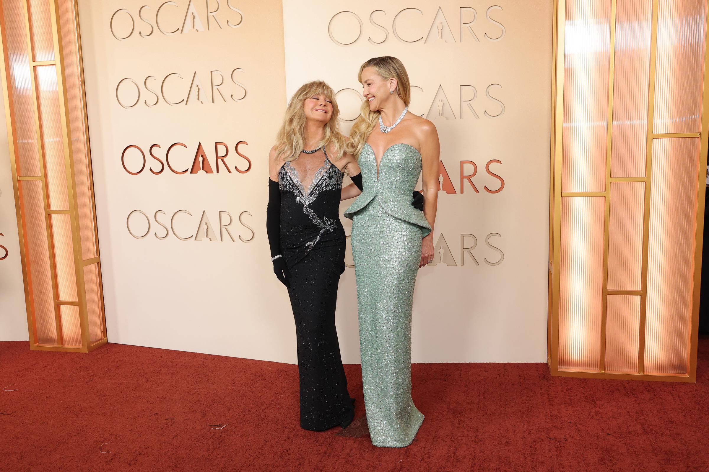 Goldie Hawn poses alongside her daughter Kate Hudson on the Oscars red carpet, the pair sharing a warm smile as they stand together in coordinating evening gowns.