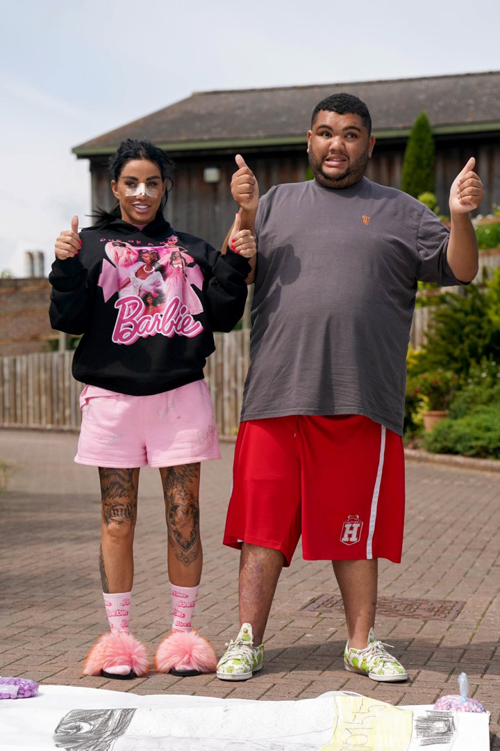 Katie and Harvey Price give a thumbs-up beside his artwork after he was presented with the Guinness World Record for the longest drawing of a train on 13 July 2023. | Source: Getty Images