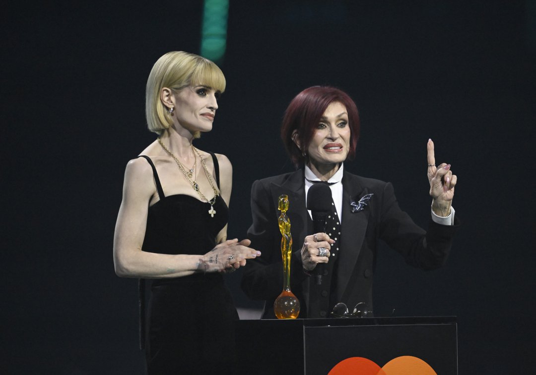 Kelly and Sharon Osbourne accept the Lifetime Achievement award on behalf of the late Ozzy Osbourne on stage during The BRIT Awards 2026 at Co-op Live on 28 February 2026 in Manchester, England. | Source: Getty Images