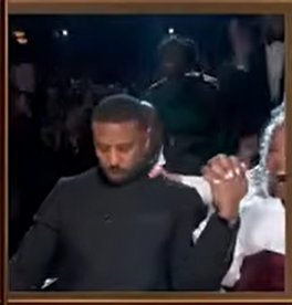 Michael B. Jordan sits in his seat with a focused, almost stunned expression as the moment unfolds around him. | Source: YouTube/ABCNews