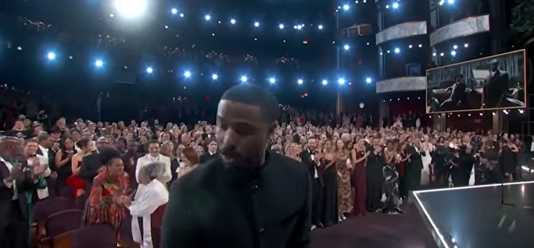 As Michael B. Jordan stepped toward the podium, Donna Jordan remained standing near her seat while people behind her congratulated her. | Source: YouTube/ABCNews